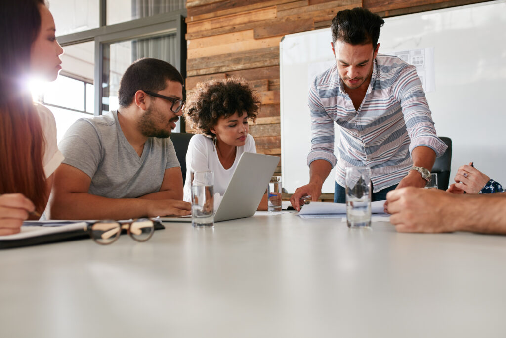 Leader showing business plan to colleagues during a meeting Leader showing business plan to colleagues during a meeting